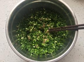 将韭菜和姜末加入肉馅中，倒入玉米油和香油