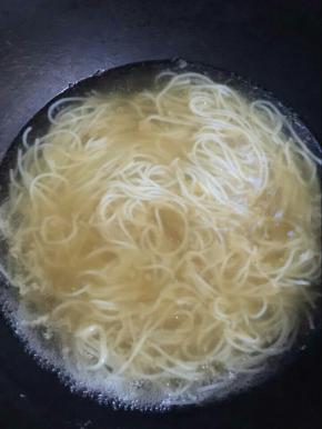 水开后放入刚刚捞起来的米粉，将浓汤倒入。
