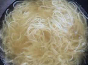 水开后放入刚刚捞起来的米粉，将浓汤倒入。
