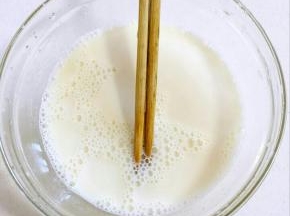 找一个大一点儿的碗，倒入白糖和牛奶，用筷子搅拌均匀至白糖融化！
