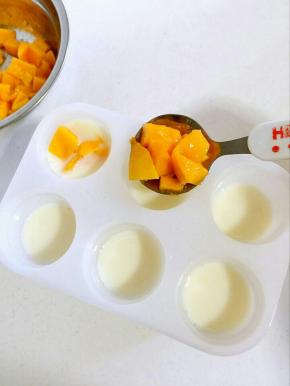 把切好的芒果粒放进雪糕模具中！9分满即可，要不然一会儿盖子盖不上啦！
