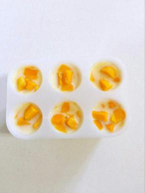 依次把所有的雪糕模具都放入芒果粒！
