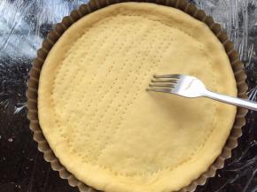 把擀好的面饼放入模具中，用刀叉叉出小孔。