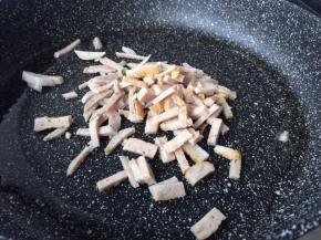 然后不粘锅用中火烧热倒入适量的花生油烧热，再放入猪肉丸跟肉卷炒1-2分钟左右。