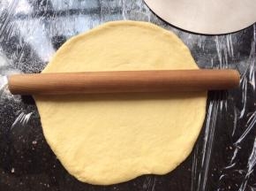 和好的面团取出放到操作台中，用擀面杖擀开成圆形装。