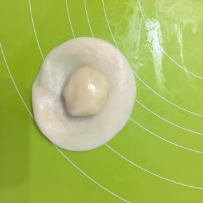 取水油皮擀成饺子皮大小包上油酥，从背后收口