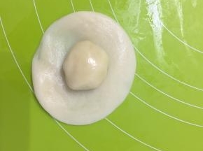 取水油皮擀成饺子皮大小包上油酥，从背后收口