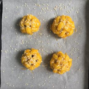 然后取出再刷一层蛋黄液，撒上白的熟芝麻，再入烤箱烤15分钟