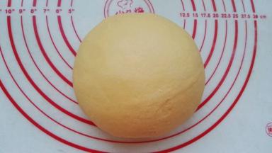 放揉面垫或案板上开始用拳头捣， 用掌跟揉、折叠，并重复此动作对面团进行排气，直到把面团揉光滑(分次撒少许干粉防粘)。