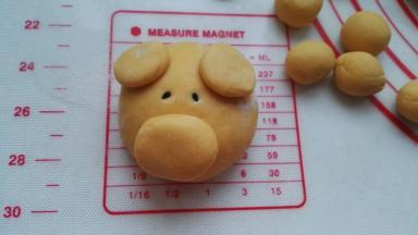 用湿筷子沾黑芝麻点上眼睛。