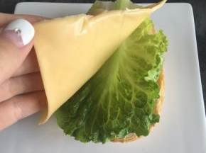 面包片上放一片生菜叶，一片芝士片