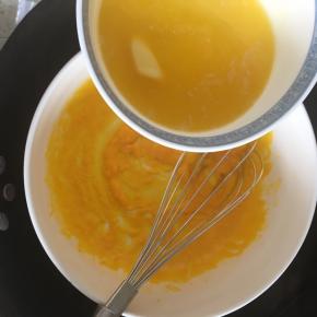 搅拌到蛋黄浓稠时分次倒入融化的黄油，继续不停搅拌，注意这个时候大锅内的水还是微微沸腾的