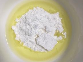 玉米油倒入碗中，加入糖粉和盐搅拌