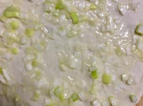 将葱花均匀的摊在面饼上