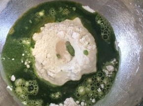 取一把菠菜榨汁过滤，面粉中挖一个小坑放入酵母，糖和盐对角线放，倒入全蛋液、60g菠菜汁