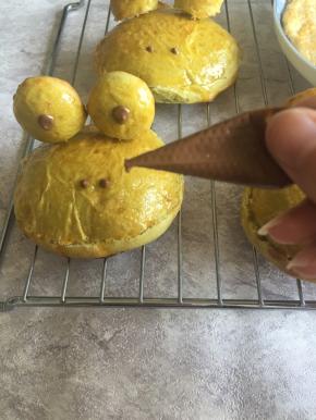 用牙签插上青蛙眼睛，用巧克力融化后点上眼睛和鼻子