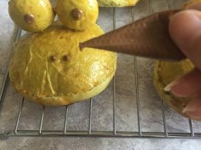 用牙签插上青蛙眼睛，用巧克力融化后点上眼睛和鼻子