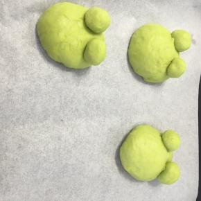 面团放在烤盘内进行第二次发酵，我当时做的时候把青蛙眼睛下搓了一个小长条，把大面团剪了口把眼睛插进去，事实证明这样不好用，大家还是先不要放上眼睛，直接发酵吧，最后利用牙签就好了