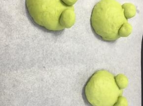 面团放在烤盘内进行第二次发酵，我当时做的时候把青蛙眼睛下搓了一个小长条，把大面团剪了口把眼睛插进去，事实证明这样不好用，大家还是先不要放上眼睛，直接发酵吧，最后利用牙签就好了