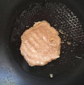 锅内放油，把鸡肉弄成饼状煎