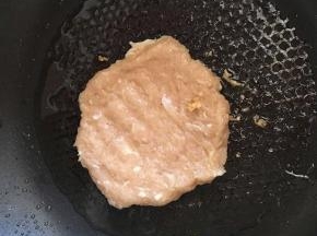 锅内放油，把鸡肉弄成饼状煎