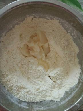 放入猪油用手捏，把猪油充分混入面粉中。不用太用力捏，只是拌匀就可以了。