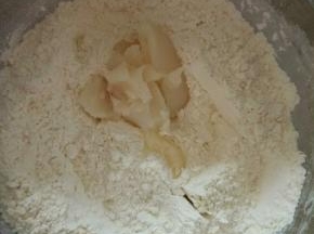 放入猪油用手捏，把猪油充分混入面粉中。不用太用力捏，只是拌匀就可以了。