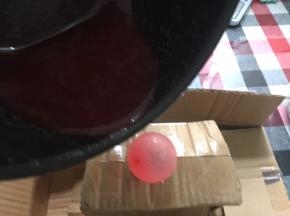 吹一个小气球，找个东西固定好位置，待珊瑚糖浆泡泡减少立马淋到气球上