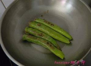 炒锅内放入少许食用油，将填好肉馅的尖椒煎至上色；