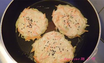 平锅内放入少许食用油，油温五成热，用小勺称出面糊放进平底锅里，用勺底将面糊摊平，再撒上几粒黑芝麻，待面饼煎至两面上色即可。