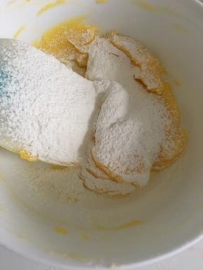 4低粉分两次筛入蛋黄糊，筛入第一次后用刮刀翻拌均匀后再第二次筛入低粉翻拌均匀