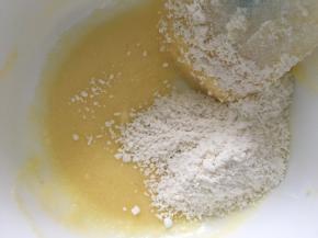 把之前混合好的椰蓉粉倒入蛋白黄油中，翻拌均匀