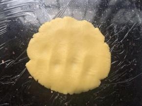 菠萝皮放操作台上手掌轻轻按压薄，压至能包下整个面团。