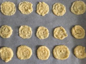 挤在铺有油纸袋烤盘上，挤的时候轻轻的转圈挤，尽量挤到大小一样大，约2毫米厚左右（没有裱花袋的可以用勺子舀在油纸上，按压的薄一点才会香脆）