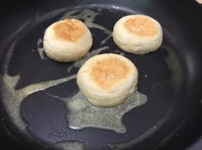 3. 用平底锅加热熔化黄油，餐包切开的一面朝下摆放
