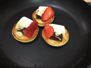 4. 烤变色之后翻面在餐包上依次摆放棉花糖，巧克力，草莓，