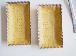 用叉子均匀的扎出小孔，烤箱预热至170度，中层，在挞皮上压上重物，烘烤10分钟左右，将重物取走，继续烘烤3分钟左右至金黄色