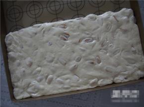 稍微晾凉后放入不沾垫上，用手揉一会儿，让棉花糖充分包裹住花生，用擀面杖擀平