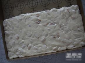 稍微晾凉后放入不沾垫上，用手揉一会儿，让棉花糖充分包裹住花生，用擀面杖擀平