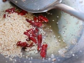 炒锅放油，烧制七成热放入红辣椒，芝麻炒香。