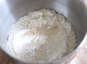 把所有原料除黄油外放入，厨师机料理盆，启动一档和面，揉至城光滑的面团后，加入黄油，启动二档继续和面。