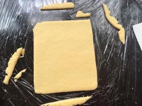 把每个味的面团都用擀面杖擀开，形成长方形状态，把不平整的边边切掉，厚度0.2-0.3mm左右，长度8cm左右。