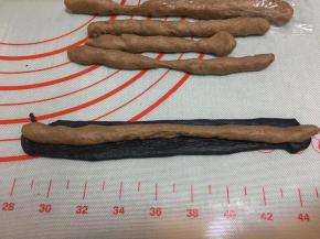 竹炭面团擀成薄长片，包裹在可可面团外面，有几个全包住，有几个半包住。这样做出来的纹路会很惊奇。