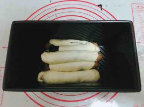 包好的面团依次放在学厨黑金刚吐司盒里。不用太刻意，最后的发酵结果肯定是很意外的。盖上保鲜膜发酵，发酵至模具八分满，烤箱预热开始预热，190度