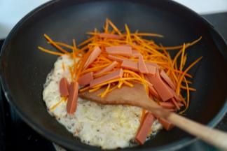 冷锅热油，先把鸡蛋稍微炒炒，然后放入胡萝卜和火腿肠，继续煸炒