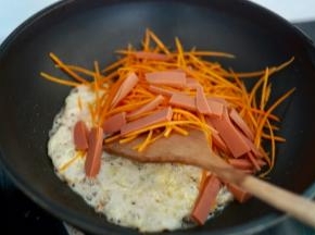 冷锅热油，先把鸡蛋稍微炒炒，然后放入胡萝卜和火腿肠，继续煸炒