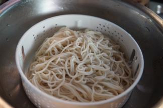 凉透的面条再放入一个沥水盆沥水分，并加少许植物油拌匀防沾