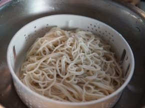 凉透的面条再放入一个沥水盆沥水分，并加少许植物油拌匀防沾