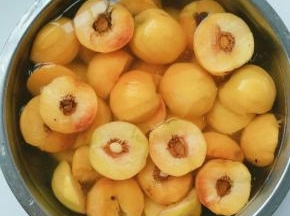 用刀从中间将桃子切成两瓣(做罐头不要买太大的桃子，贵而且对半切开可能放不进瓶口还在再切开，增加工作量还不好看，大小中等的桃子中间切开正好放进瓶子，好看还省事)