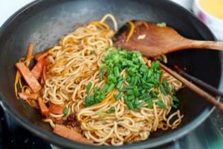 翻炒均匀的面条撒入香葱即可